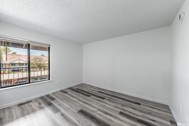 1465 E Peckham Ln Apt 20, Reno, NV 89502 - spare room featuring a textured ceiling, wood finished floors, and baseboards