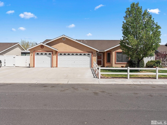 1343 White Bluffs Cir, Fernley, NV 89408 - ranch-style house featuring a garage, driveway, a gate, and stucco siding