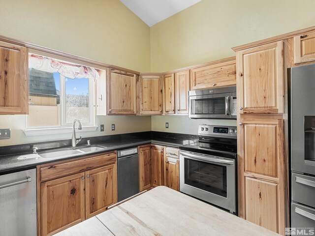 1343 White Bluffs Cir, Fernley, NV 89408 - kitchen featuring appliances with stainless steel finishes, a sink, vaulted ceiling, and dark countertops