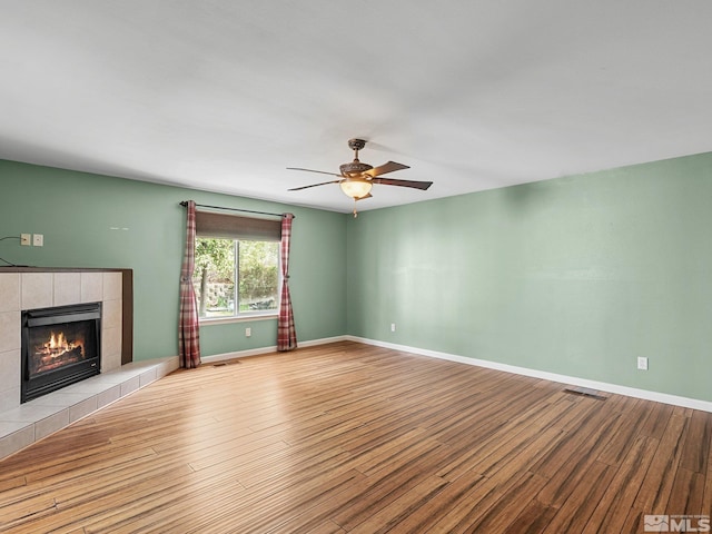 1343 White Bluffs Cir, Fernley, NV 89408 - unfurnished living room featuring wood finished floors, a fireplace, ceiling fan, and baseboards