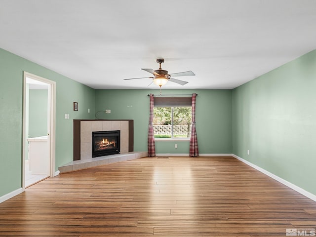 1343 White Bluffs Cir, Fernley, NV 89408 - unfurnished living room with wood finished floors, ceiling fan, a fireplace, and baseboards
