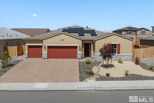 2444 Butte Creek Dr, Sparks, NV 89436 - view of front of house featuring stone siding, an attached garage, stucco siding, and solar panels