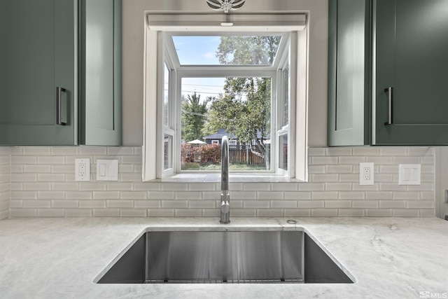 823 Arbutus St, Reno, NV 89509 - kitchen featuring green cabinetry, a sink, light stone countertops, and backsplash