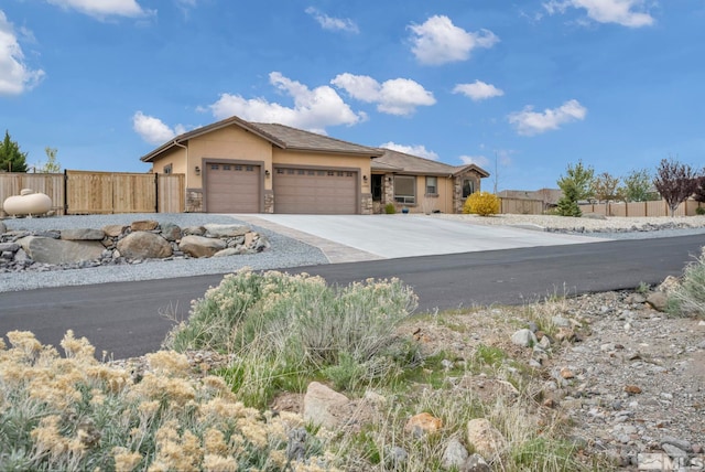 16885 Majestic View Dr, Reno, NV 89521 - view of front of house featuring a garage, stone siding, fence, and concrete driveway