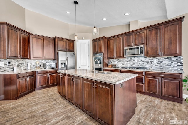 16885 Majestic View Dr, Reno, NV 89521 - kitchen featuring stainless steel appliances, a sink, tasteful backsplash, an island with sink, and decorative light fixtures