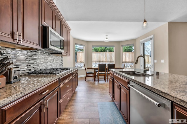 16885 Majestic View Dr, Reno, NV 89521 - kitchen with stainless steel appliances, a sink, tasteful backsplash, dark stone counters, and wood finished floors