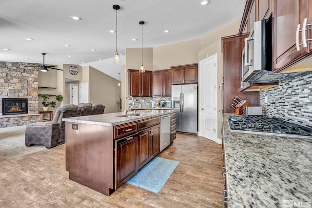 16885 Majestic View Dr, Reno, NV 89521 - kitchen with stainless steel appliances, a sink, a ceiling fan, open floor plan, and a fireplace