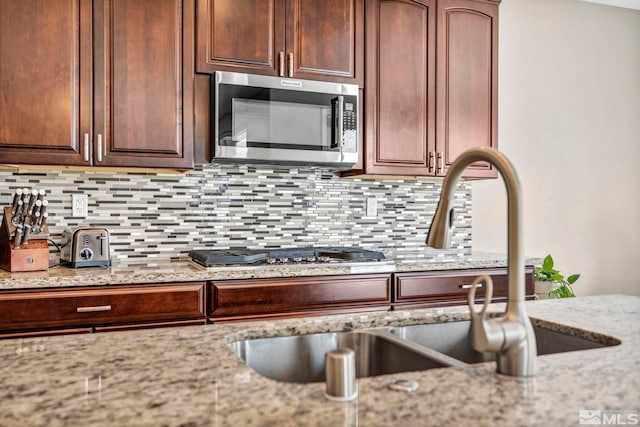 16885 Majestic View Dr, Reno, NV 89521 - kitchen with stainless steel appliances, a sink, tasteful backsplash, and light stone counters