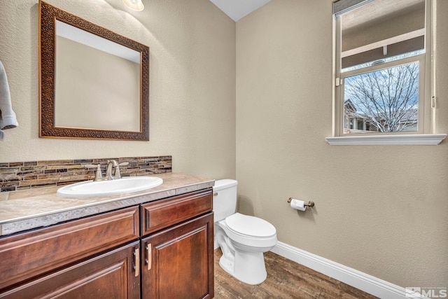 16885 Majestic View Dr, Reno, NV 89521 - bathroom featuring baseboards, wood finished floors, toilet, vanity, and decorative backsplash
