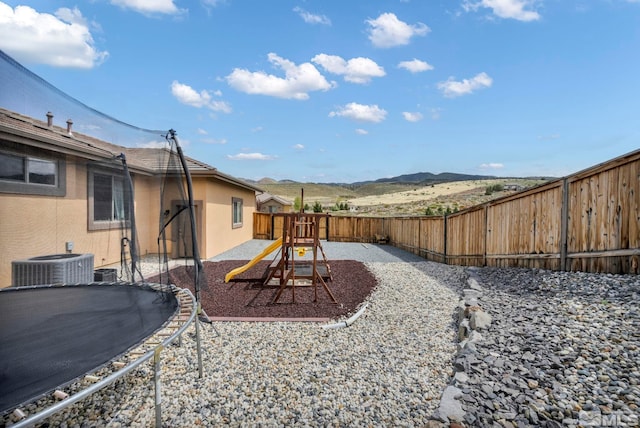 16885 Majestic View Dr, Reno, NV 89521 - fenced backyard featuring a trampoline, a playground, central AC unit, and a mountain view