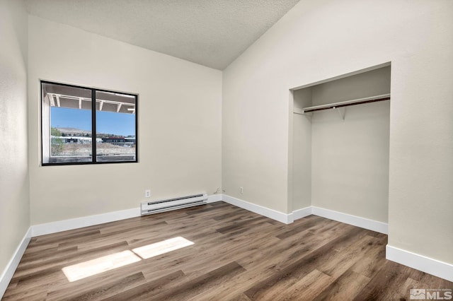 2375 Tripp Dr Unit 2, Reno, NV 89512 - unfurnished bedroom with baseboard heating, vaulted ceiling, wood finished floors, baseboards, and a closet