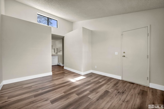 2375 Tripp Dr Unit 2, Reno, NV 89512 - empty room with wood finished floors, baseboards, a textured ceiling, and a towering ceiling