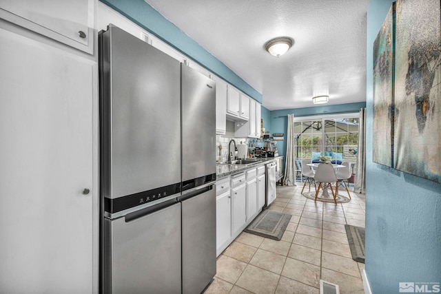 40 Condor Cir, Carson City, NV 89701 - kitchen featuring appliances with stainless steel finishes, a sink, white cabinetry, a textured ceiling, and light tile patterned flooring