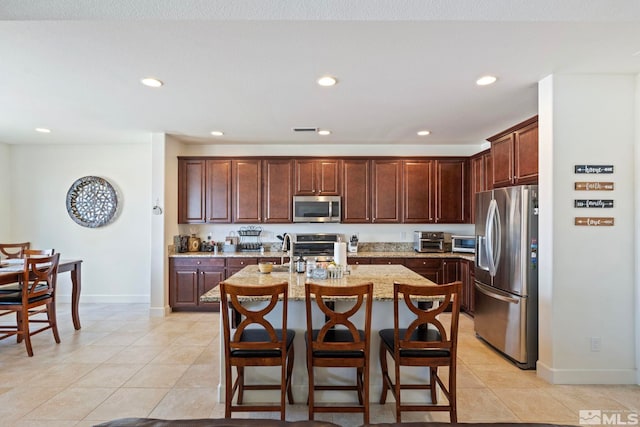1845 Fledge Creek Dr, Reno, NV 89521 - kitchen with appliances with stainless steel finishes, baseboards, light tile patterned floors, recessed lighting, and light stone countertops