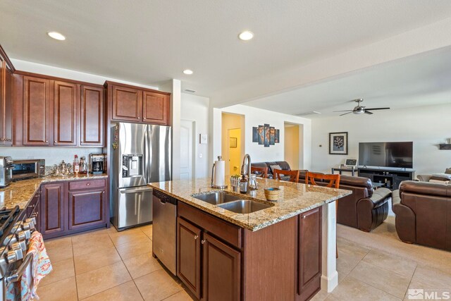 1845 Fledge Creek Dr, Reno, NV 89521 - kitchen featuring a sink, stainless steel appliances, open floor plan, light stone countertops, and light tile patterned floors