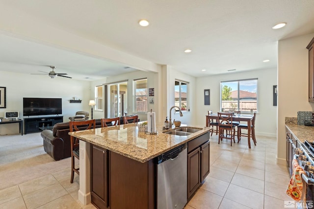 1845 Fledge Creek Dr, Reno, NV 89521 - kitchen with stainless steel appliances, a sink, light tile patterned flooring, a breakfast bar area, and an island with sink