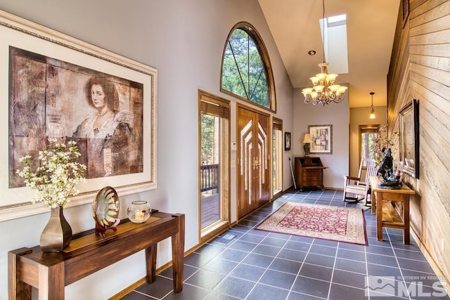 1300 Douglas Fir Dr, Reno, NV 89511 - foyer entrance with plenty of natural light, high vaulted ceiling, a chandelier, dark tile patterned flooring, and wooden walls