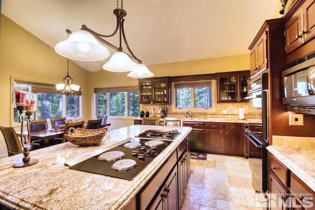 1300 Douglas Fir Dr, Reno, NV 89511 - kitchen with black appliances, light stone finish floors, vaulted ceiling, glass insert cabinets, and backsplash