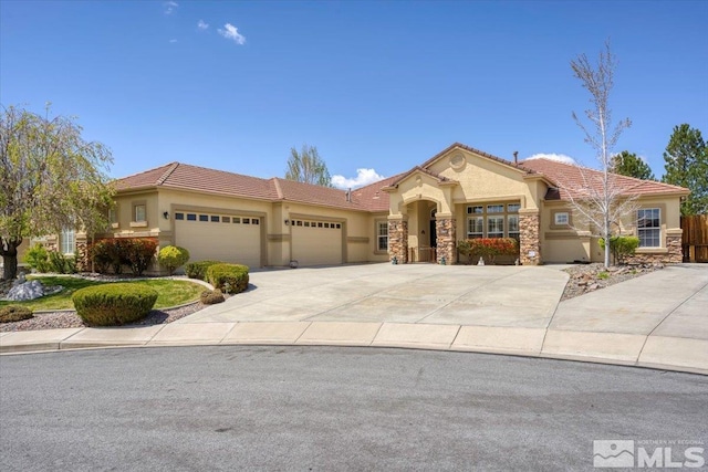 mediterranean / spanish-style house featuring a garage, stucco siding, and a tile roof