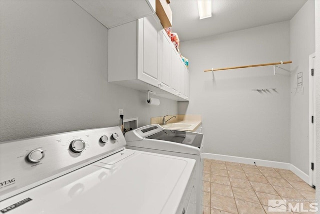 washroom with cabinet space, independent washer and dryer, baseboards, and light tile patterned floors