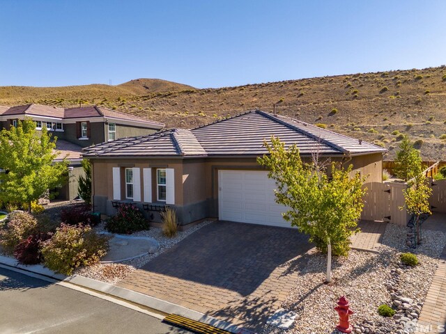 3335 Show Jumper, Reno, NV 89521 - prairie-style home featuring an attached garage, a tiled roof, a mountain view, driveway, and stucco siding