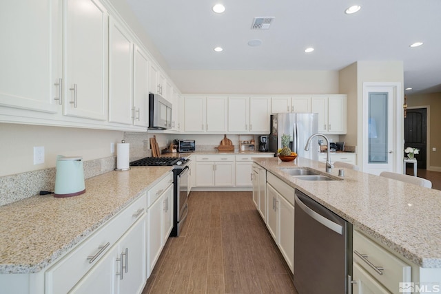 3335 Show Jumper, Reno, NV 89521 - kitchen featuring stainless steel appliances, a sink, a center island with sink, white cabinets, and recessed lighting