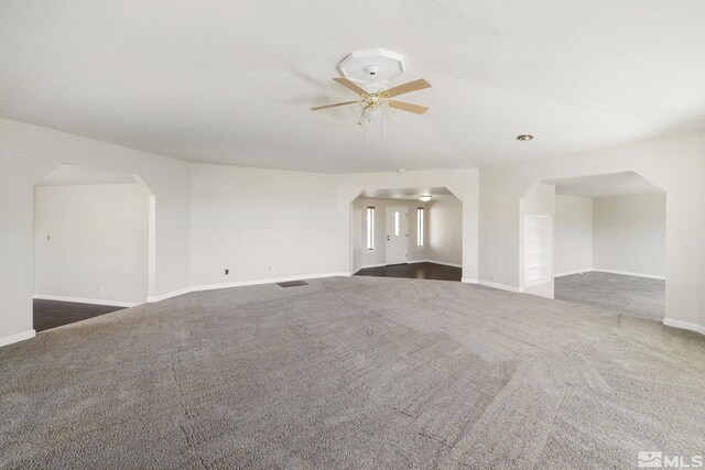 9499 Wigwam Way, Reno, NV 89506 - unfurnished room featuring dark colored carpet, a ceiling fan, arched walkways, and baseboards