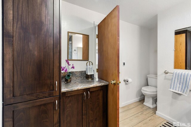 9499 Wigwam Way, Reno, NV 89506 - bathroom featuring baseboards, toilet, vanity, and wood finished floors