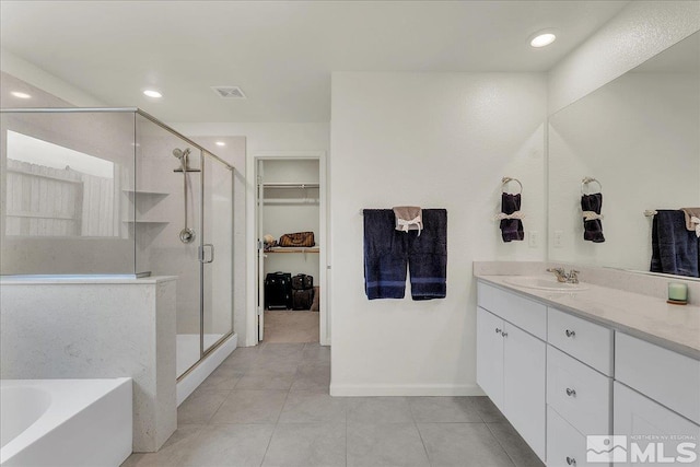 286 Greywall Ct, Dayton, NV 89403 - bathroom with tile patterned floors, a shower stall, vanity, a bath, and a walk in closet