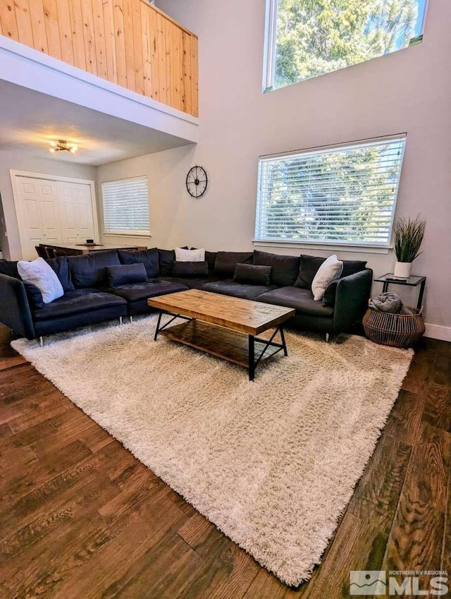 416 Quaking Aspen Ln Unit P, Stateline, NV 89449 - living room featuring dark wood-style floors, healthy amount of natural light, a high ceiling, and baseboards