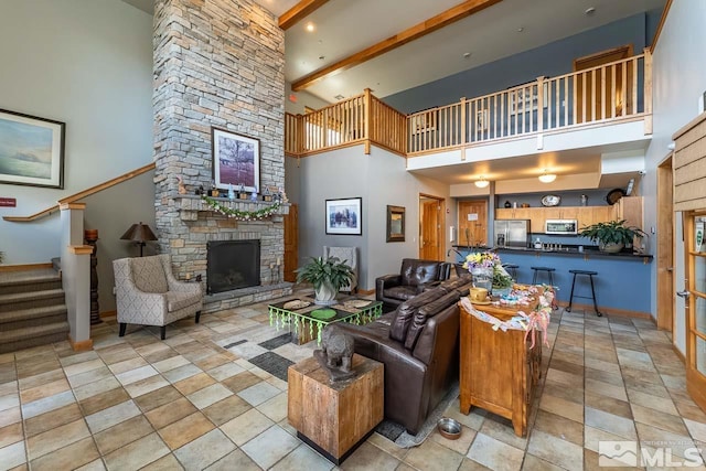 1450 Idlewild Dr Unit 1121, Reno, NV 89509 - living area with a high ceiling, a fireplace, stairway, light stone finish flooring, and beamed ceiling