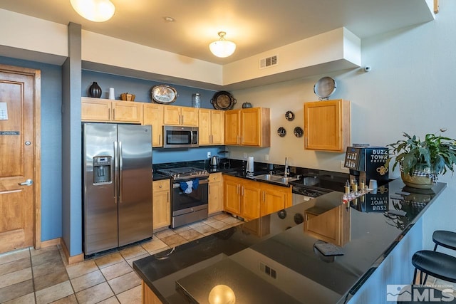 1450 Idlewild Dr Unit 1121, Reno, NV 89509 - kitchen with appliances with stainless steel finishes, a sink, a peninsula, dark countertops, and a breakfast bar