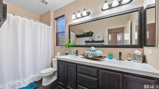 2485 Firenze Dr, Sparks, NV 89434 - full bath with toilet, double vanity, a shower with shower curtain, and wood finished floors
