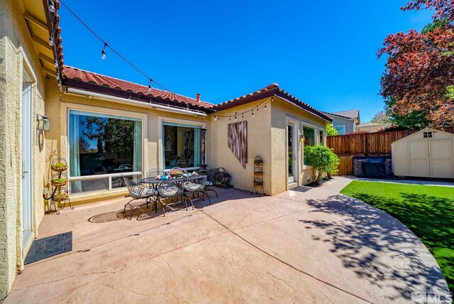 2485 Firenze Dr, Sparks, NV 89434 - rear view of house featuring a tiled roof, stucco siding, a storage unit, and a patio