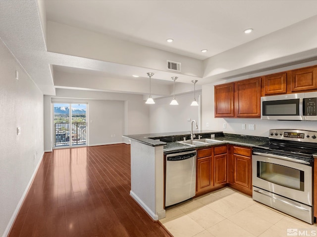 200 W 2nd Unit 1508, Reno, NV 89501 - kitchen with appliances with stainless steel finishes, a sink, a peninsula, open floor plan, and brown cabinetry