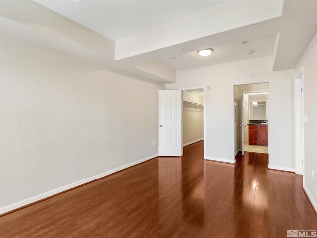 200 W 2nd Unit 1508, Reno, NV 89501 - unfurnished bedroom with dark wood-style flooring, a spacious closet, baseboards, and a closet