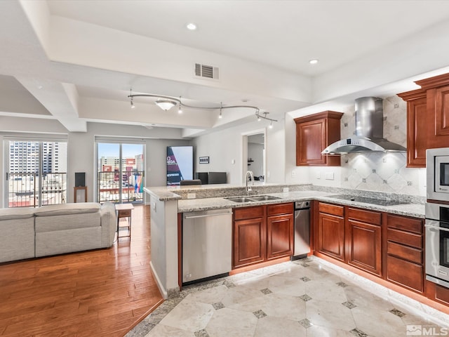 200 W 2nd Unit 1104, Reno, NV 89501 - kitchen with a sink, appliances with stainless steel finishes, wall chimney exhaust hood, open floor plan, and a peninsula