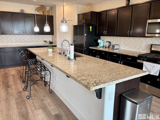 2269 Millville Dr, Sparks, NV 89441 - kitchen with stainless steel appliances, a sink, light wood-style flooring, and a kitchen breakfast bar