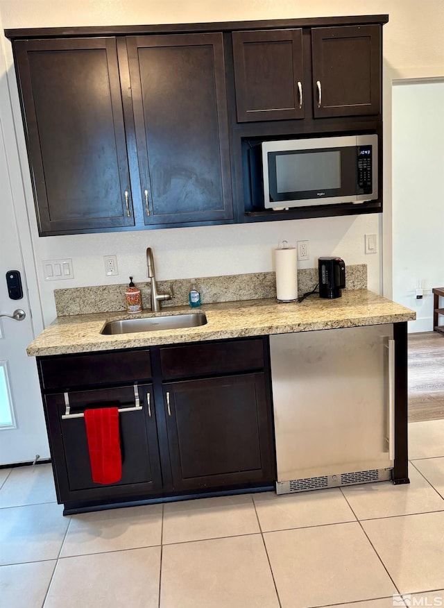 2269 Millville Dr, Sparks, NV 89441 - kitchen featuring stainless steel microwave, a sink, dark brown cabinets, and light tile patterned floors