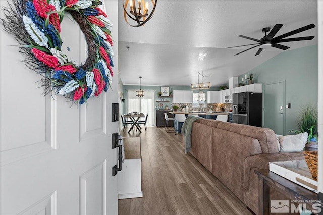 2036 Flycatcher Ct, Sparks, NV 89441 - living room featuring a chandelier, wood finished floors, ceiling fan, and vaulted ceiling