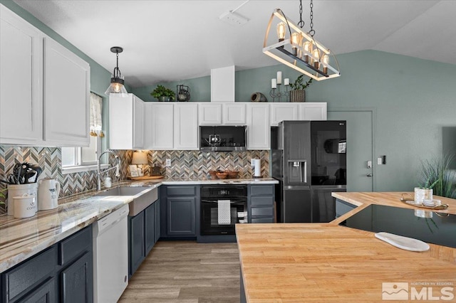 2036 Flycatcher Ct, Sparks, NV 89441 - kitchen with black appliances, vaulted ceiling, light wood-style floors, white cabinets, and decorative backsplash