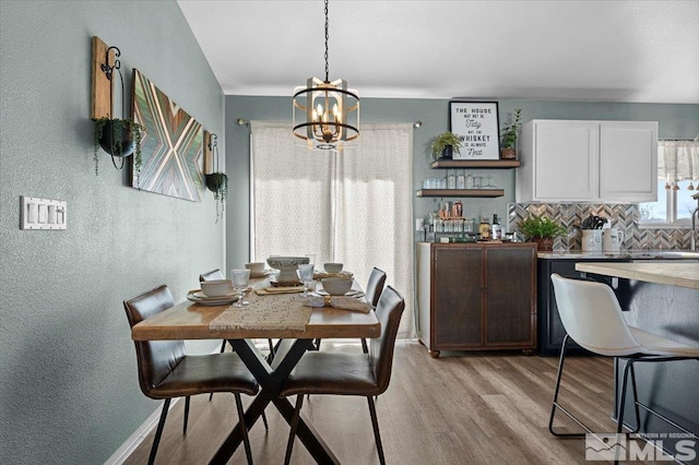 2036 Flycatcher Ct, Sparks, NV 89441 - dining area with a chandelier, a textured wall, and light wood finished floors