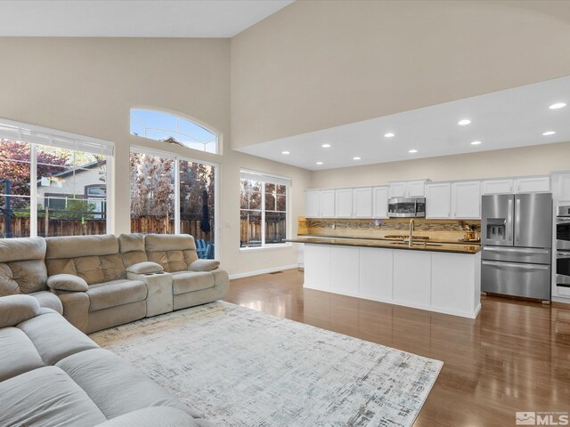 3240 Dunbar Ct, Sparks, NV 89436 - living room featuring high vaulted ceiling, wood finished floors, recessed lighting, and baseboards