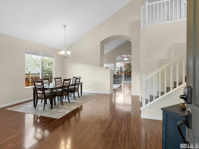 3240 Dunbar Ct, Sparks, NV 89436 - dining space with high vaulted ceiling, arched walkways, dark wood finished floors, stairway, and baseboards