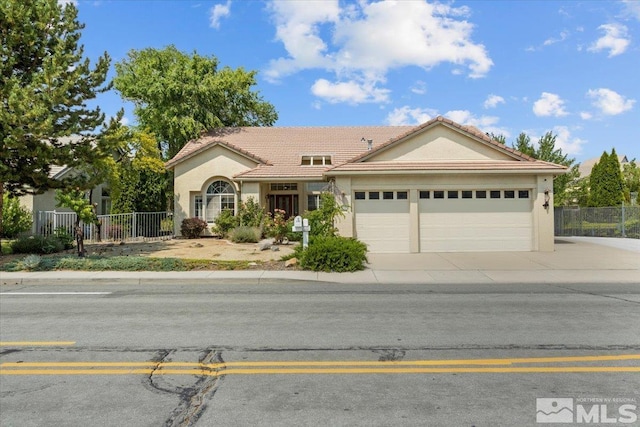 2525 Beaumont Pkwy, Reno, NV 89523 - ranch-style house featuring an attached garage, a tiled roof, fence, concrete driveway, and stucco siding