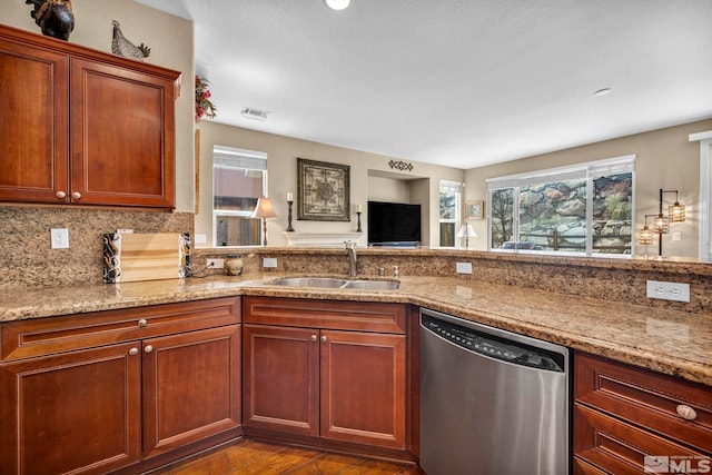 kitchen with stainless steel dishwasher, a sink, light stone countertops, dark wood finished floors, and backsplash