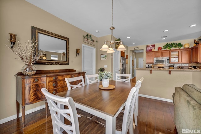 dining area featuring dark wood-type flooring, recessed lighting, baseboards, and a chandelier