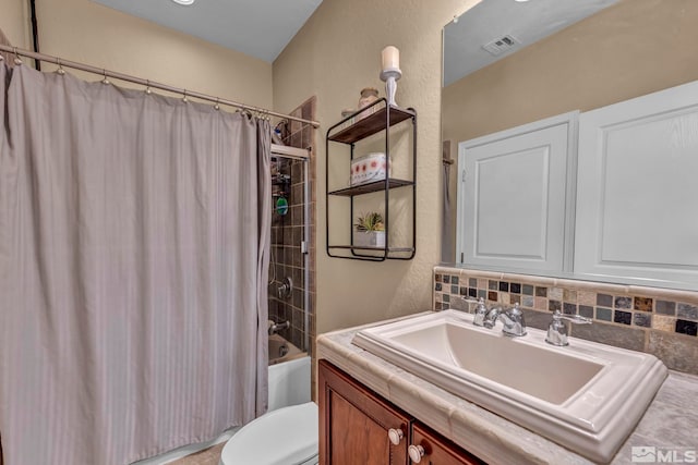 bathroom with shower / bath combo, toilet, vanity, decorative backsplash, and a textured wall