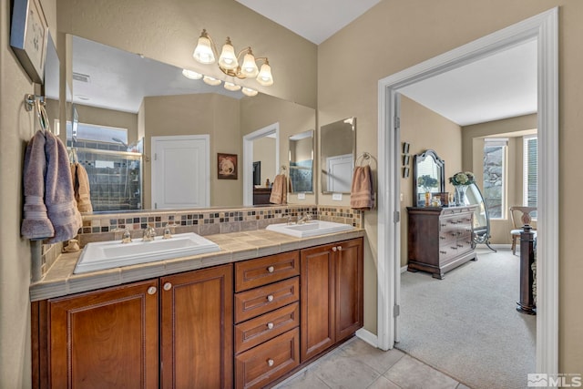 full bath with a shower stall, double vanity, tasteful backsplash, tile patterned floors, and baseboards