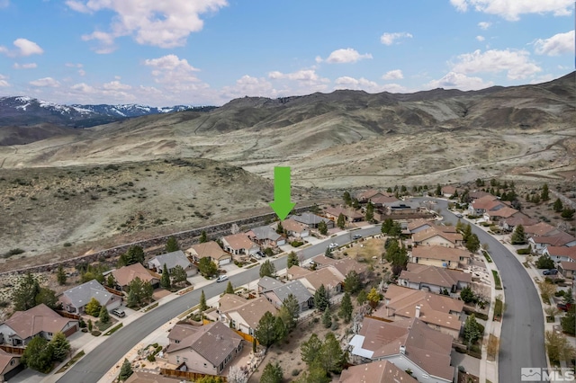 aerial view of property and surrounding area featuring a mountainous background and nearby suburban area